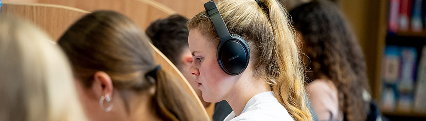 A student using headphones in a study booth 